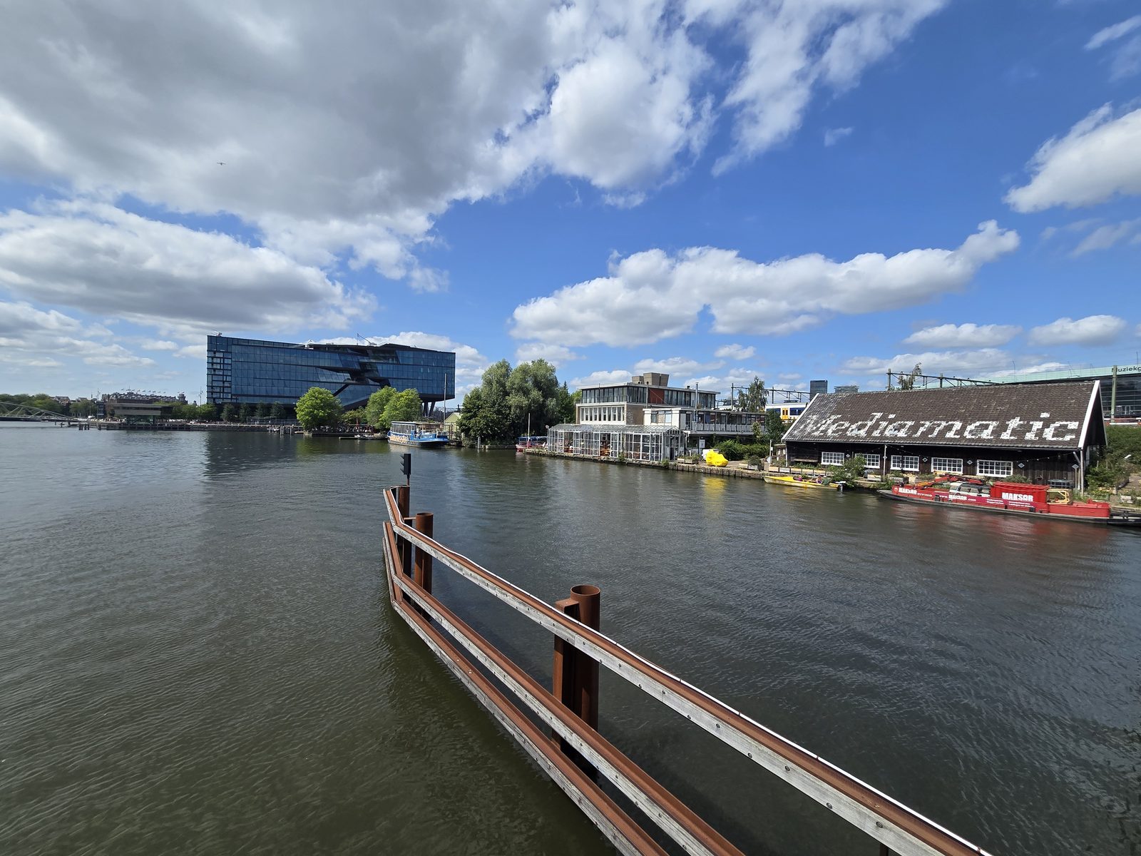 Amsterdam's waterfront, where the reclaimed Mediamatic sustainable art space and modern glass architecture meet the water.