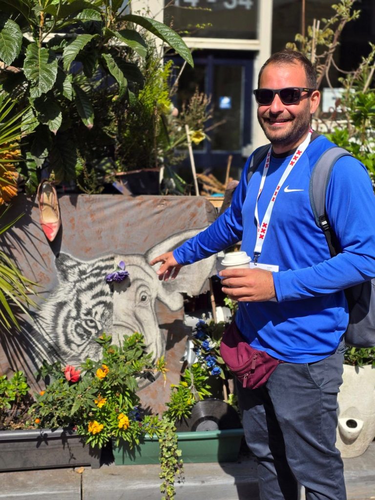 Antonis beside an elephant mural in an Amsterdam street garden