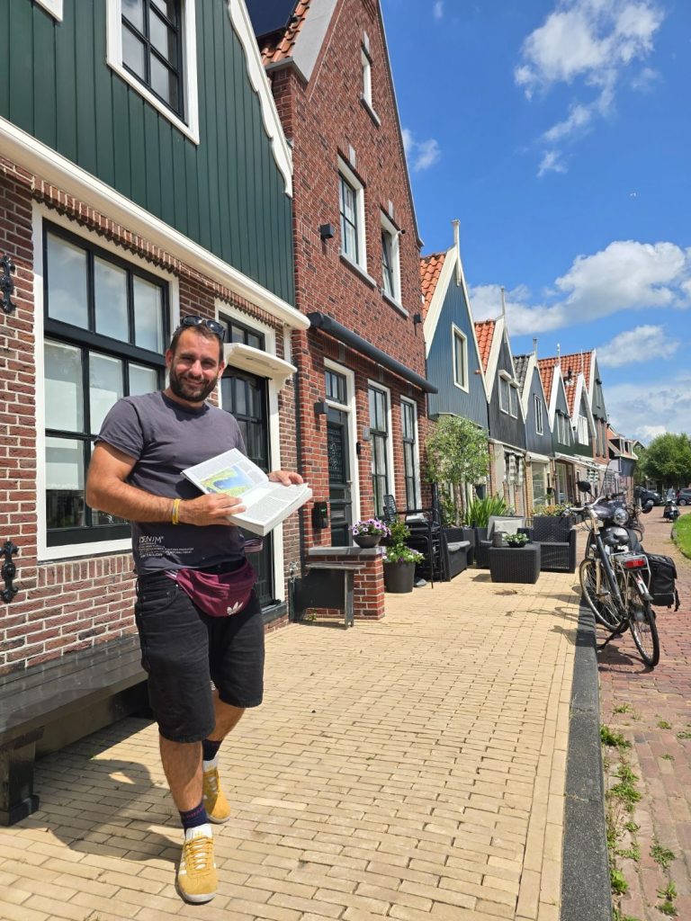Antonis telling a story between the wooden houses of Volendam